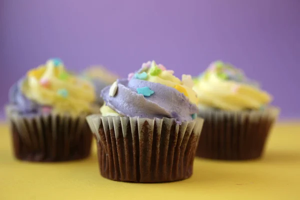 Three Easter Yellow Lilac Chocolate Cupcakes Candies Yellow Purple Background — Stock Photo, Image