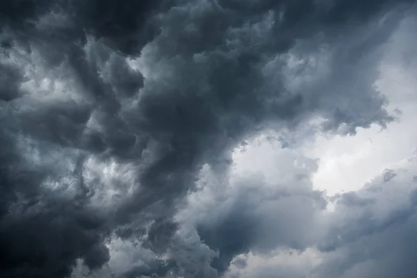 Fond de nuages sombres avant un orage, lumière du soleil à travers des nuages très sombres, Trou blanc dans le tourbillon de nuages orageux sombres — Photo