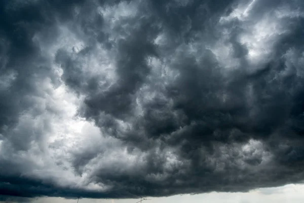 Fond de nuages sombres avant un orage, lumière du soleil à travers des nuages très sombres, Trou blanc dans le tourbillon de nuages orageux sombres — Photo