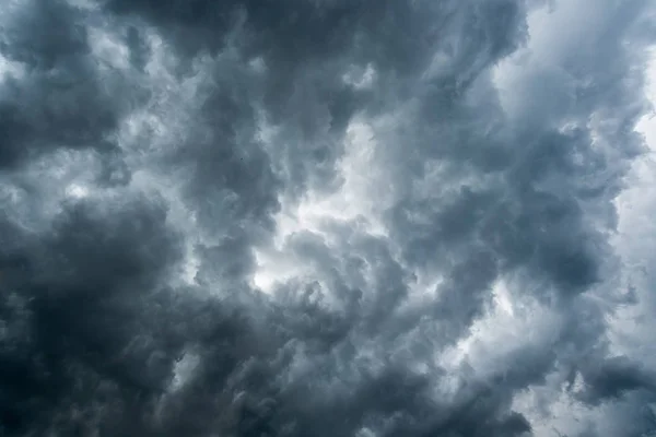 Fond de nuages sombres avant un orage, lumière du soleil à travers des nuages très sombres, Trou blanc dans le tourbillon de nuages orageux sombres — Photo