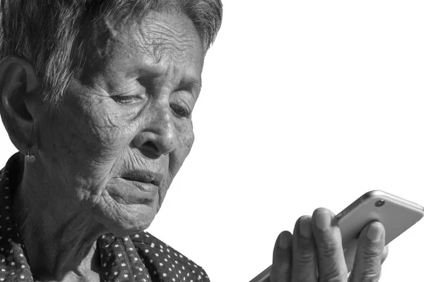 Старшая женщина играет на смартфоне — стоковое фото