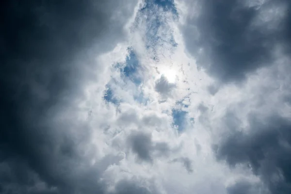 Nuvole con sfondo, luce solare attraverso nuvole molto scure sfondo di nubi buie tempesta, cielo nero sfondo di nuvole scure prima di un tuono . — Foto Stock