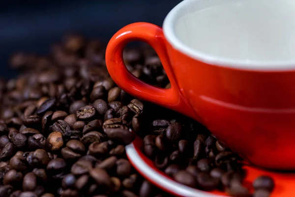 T kawy w czerwony kubek i ziarna kawy są tłem. — Zdjęcie stockowe
