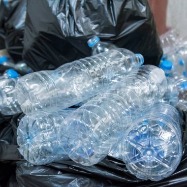 Siyah çöp torbalarındaki plastik şişeler geri dönüşüm için alınmayı bekliyor..
