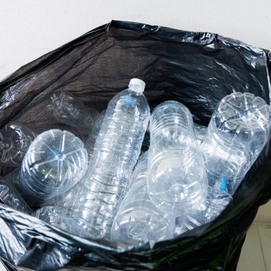 Siyah çöp torbalarındaki plastik şişeler geri dönüşüm için alınmayı bekliyor..