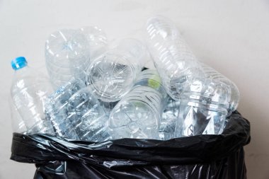 Siyah çöp torbalarındaki plastik şişeler geri dönüşüm için alınmayı bekliyor..
