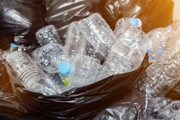 Siyah çöp torbalarındaki plastik şişeler geri dönüşüm için alınmayı bekliyor..