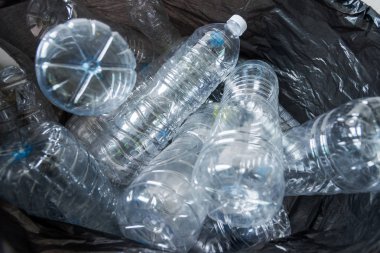 Siyah çöp torbalarındaki plastik şişeler geri dönüşüm için alınmayı bekliyor..