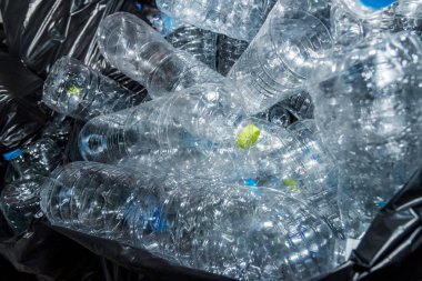 Siyah çöp torbalarındaki plastik şişeler geri dönüşüm için alınmayı bekliyor..