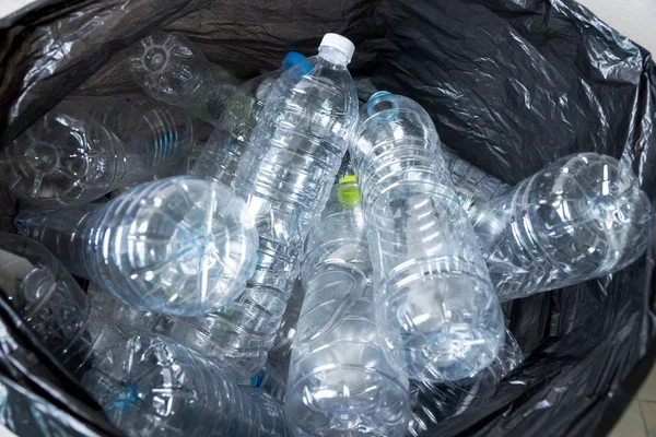 Siyah çöp torbalarındaki plastik şişeler geri dönüşüm için alınmayı bekliyor..
