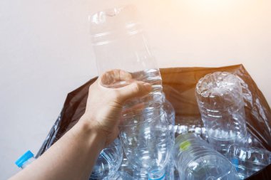 Siyah çöp torbalarındaki plastik şişeler geri dönüşüm için alınmayı bekliyor..