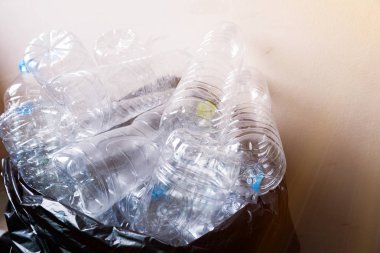 Siyah çöp torbalarındaki plastik şişeler geri dönüşüm için alınmayı bekliyor..