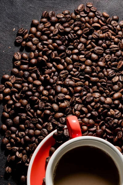 coffee in red cup and coffee beans are the background.