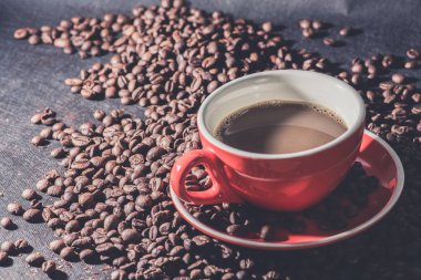 kahve kırmızı Kupası ve kahve çekirdekleri arka plan vardır.