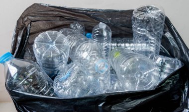 Siyah çöp torbalarındaki plastik şişeler geri dönüşüm için alınmayı bekliyor..