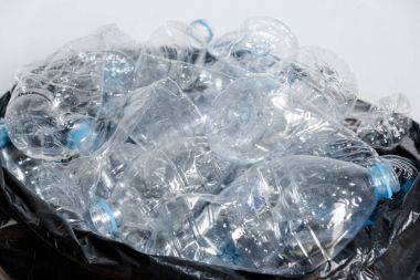 Siyah çöp torbalarındaki plastik şişeler geri dönüşüm için alınmayı bekliyor..