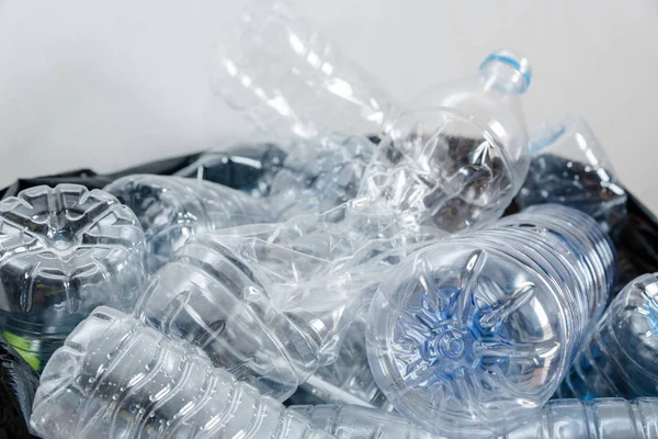 Siyah çöp torbalarındaki plastik şişeler geri dönüşüm için alınmayı bekliyor..
