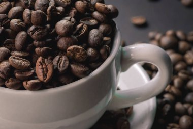 kahve beyaz Kupası ve kahve çekirdekleri arka plan vardır.