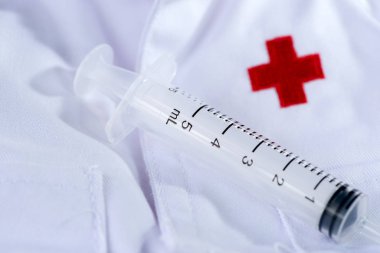 Beyaz arka planda Kızıl Haç, şırınga (enjeksiyon iğnesi).