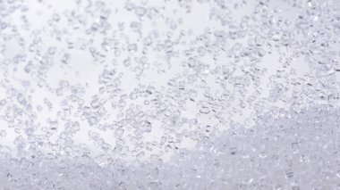 Beyaz arkaplanda cam şişelerdeki kristal şekeri kapat.