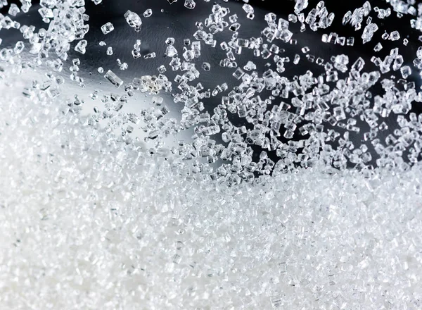 Beyaz arkaplanda cam şişelerdeki kristal şekeri kapat.