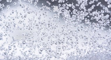 Beyaz arkaplanda cam şişelerdeki kristal şekeri kapat.