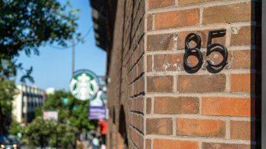 85 numara, tuğla duvardaki metalden yapılmış.