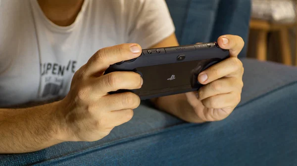 Chico jugando con Sony PS Vita - consola de juegos de PlayStation portátil Imágenes de stock libres de derechos