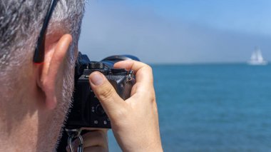San Francisco, ABD - Ağustos 2019: Güneşli bir günde bir yatın fotoğrafını çeken adam