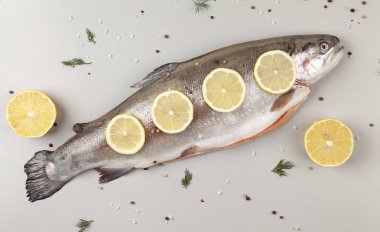 Gökkuşağı alabalığı, bitkiler ve baharatlarla pişirmeye hazır. Taze gökkuşağı alabalığı, tuzlu, biberli ve limonlu. Lezzetli balık öğle yemeği için hazırlanıyor..  