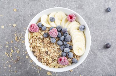 Granola, ahududu, yabanmersini ve muzlu meyve suyu kasesi. Müsli, böğürtlen ve meyveli lezzetli kahvaltı. Detoks kavramı ve sağlıklı yiyecekler. 