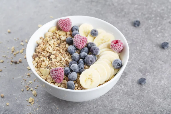 Tazón Batido Con Granola Frambuesas Arándanos Plátanos Sobre Fondo Gris —  Fotos de Stock