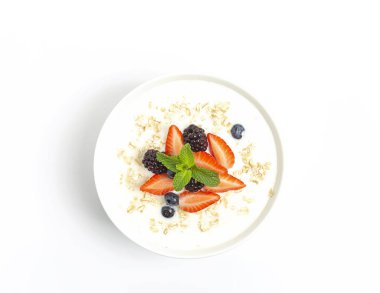 Mısır gevrekli yoğurt taze çilek, yabanmersini, böğürtlen ve beyaz masada badem. Sağlıklı atıştırmalıklar. Kahvaltı hazır.. 