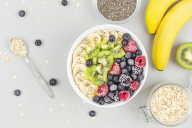 Ahududu, yabanmersini, kivi, muz, böğürtlen ve çekirdekli chia soslu sağlıklı kahvaltı smoothie kasesi. Vejetaryen yemeği. 