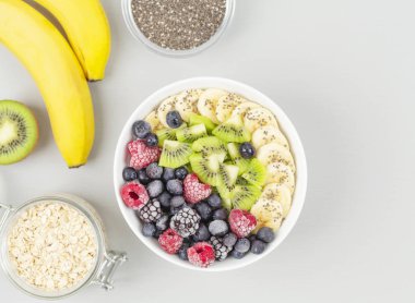 Ahududu, yabanmersini, kivi, muz, böğürtlen ve çekirdekli chia soslu sağlıklı kahvaltı smoothie kasesi. Vejetaryen yemeği. 