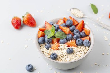 Sağlıklı meyve suyu kasesi granola, taze çilek, yabanmersini, muz, yoğurt ve nane. Sağlıklı yemek, atıştırmalık ya da kahvaltı. 