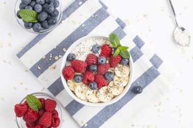 Kahvaltıda granola, taze ahududu, yabanmersini, muz, hindistan cevizi gevreği, Chia tohumu ve nane. Sağlıklı yemek.. 