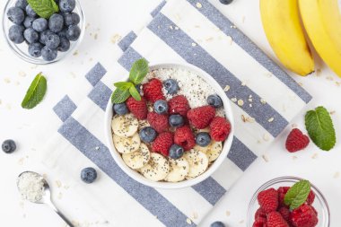 Kahvaltıda granola, taze ahududu, yabanmersini, muz, hindistan cevizi gevreği, Chia tohumu ve nane. Sağlıklı yemek.. 