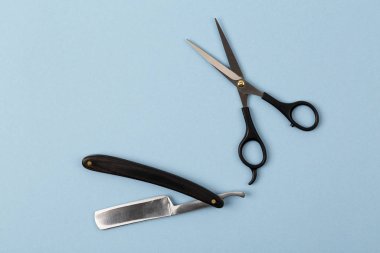 Mavi arka planda tıraş aletleri kuaförlü kompozisyon. Berber dükkanı geçmişi.