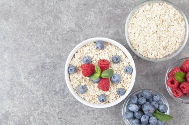 Sağlıklı kahvaltı için bir kase yulaf gevreği, taze ahududu, yaban mersini ve nane şekeri. Meyvelerle süslenmiş mısır gevreği.. 