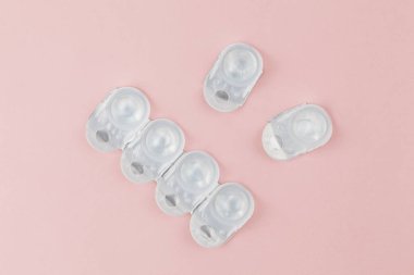 Kontakt lens paketleri pembe arkaplanlıdır. Bir yığın tek kullanımlık kontakt lens. Düz konum