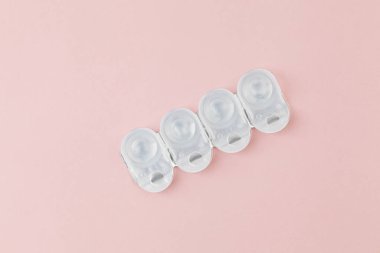 Kontakt lens paketleri pembe arkaplanlıdır. Bir yığın tek kullanımlık kontakt lens. Düz konum