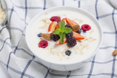 Tahıllı yoğurt, taze çilek, ahududu, yabanmersini, böğürtlen, badem ve nane. Sağlıklı atıştırmalıklar. Kahvaltı hazır.. 