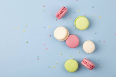 Pasta ya da mavi arka planda badem kurabiyesi, renkli badem kurabiyeleri. Tatlı üzerine Fransız badem kurabiyesi..