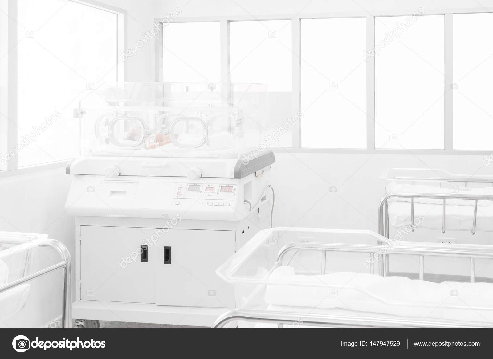 Newborn baby covered inside incubator in hospital postdelivery room