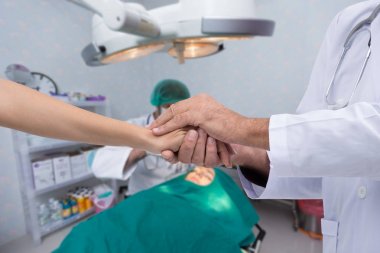 Doktorlar tedavi iyi gidiyor hastanın güven verici yakınlarına el