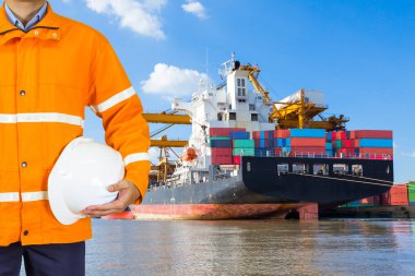 Emanet bir palto giyiyor ve kask tutan mühendisi dockers