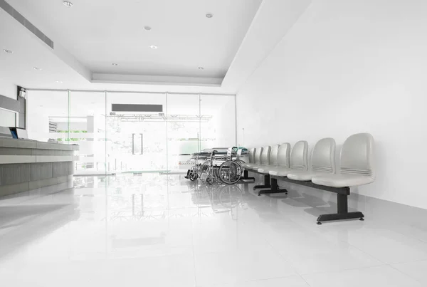 Места и инвалидное кресло в коридоре больницы — стоковое фото
