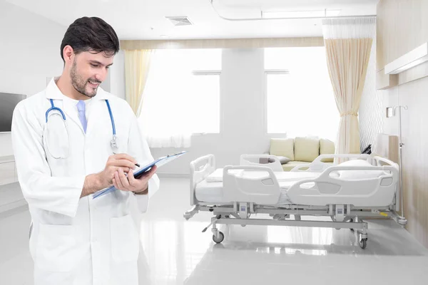 Médico escrevendo registros médicos em quarto de hospital moderno com camas — Fotografia de Stock