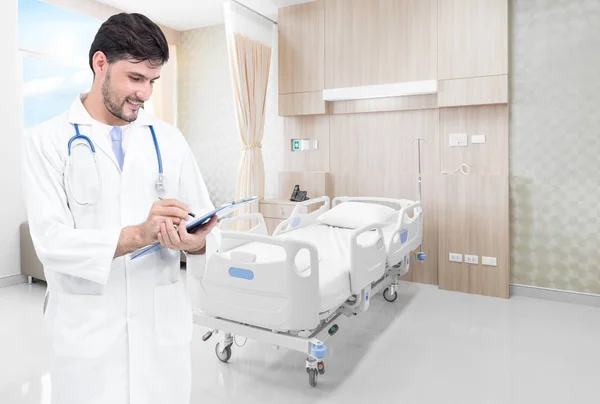 Médico escrevendo registros médicos em quarto de hospital moderno com camas e confortável médico equipado — Fotografia de Stock